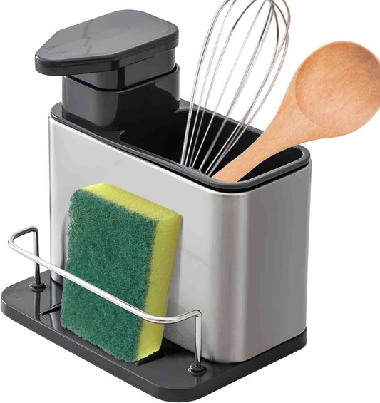 Stainless steel kitchen utensil holder with sponge, soap dispenser, whisk, and wooden spoon on a white background.
